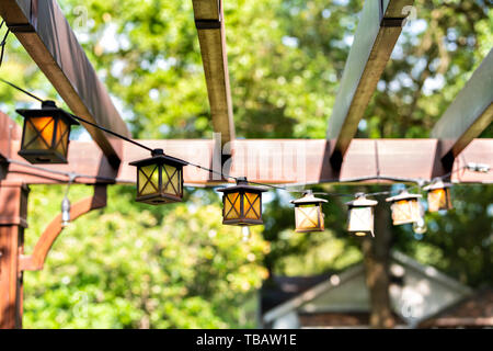 Gros plan du patio piscine jardin de printemps dans la cour de la maison avec des lumières de lampes lanternes suspendues à pergola canopy gazebo en bois et des plantes Banque D'Images