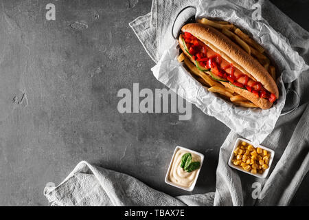 La composition avec de savoureux hot-dog sur fond gris Banque D'Images