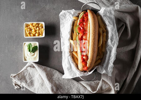 La composition avec de savoureux hot-dog sur fond gris Banque D'Images