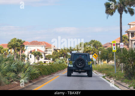 Destin, USA - Le 24 avril 2018 : Rue avec voiture, pam arbres au bord de route à la plage de Miramar ville ou village avec des maisons de style espagnol sur l'été journée ensoleillée en Flo Banque D'Images