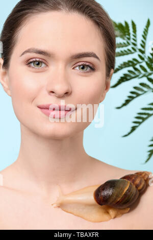 Jeune femme avec escargot Achatina géant sur un fond de couleur Banque D'Images