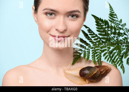 Jeune femme avec escargot Achatina géant sur un fond de couleur Banque D'Images