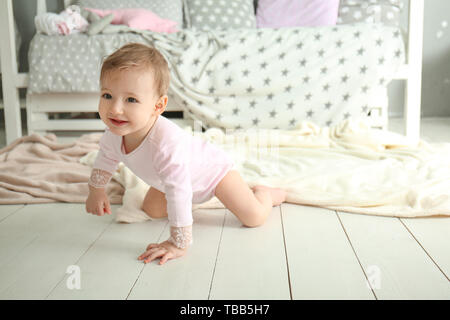 Cute baby girl ramper sur le plancher Banque D'Images