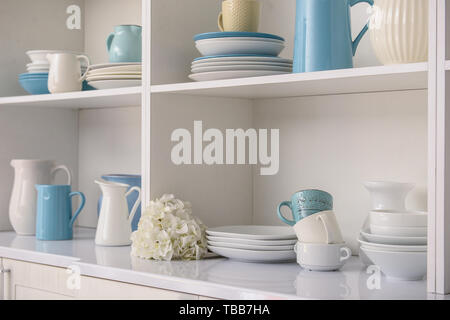 Ensemble de vaisselle propre sur étagères blanches dans la cuisine Banque D'Images