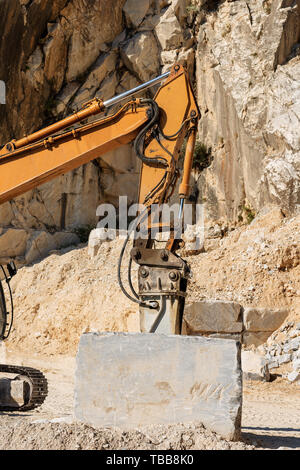 Avec l'excavatrice tracker Orange jackhammer dans une carrière de marbre blanc de Carrare (en) dans les Alpes Apuanes (Alpes Apuanes). Toscane (Toscana, Italie) Banque D'Images