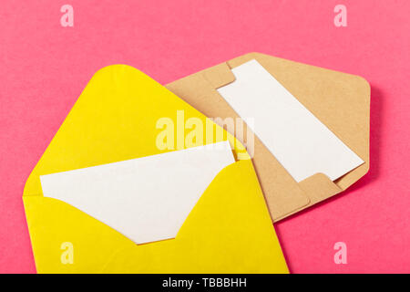 Enveloppes en papier de couleur sur un fond rose Banque D'Images