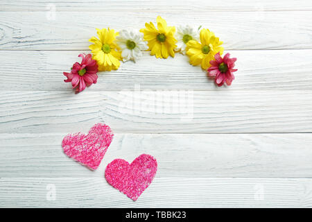 Coeurs roses avec de belles fleurs blanches sur fond de bois Banque D'Images