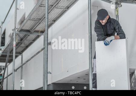 Young Entrepreneur de Construction Worker dans la trentaine avec pièce d'isolement marche sur un échafaudage. Banque D'Images