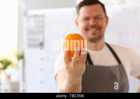 Smiling Chef Holding Vlogger Ingrédient Orange Banque D'Images