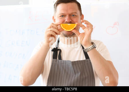 Vlogger Chef Holding Orange Slice sourire Fruits Banque D'Images