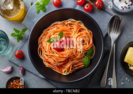 Les pâtes, spaghetti à la sauce tomate dans un bol noir sur fond noir en gris. Vue d'en haut. Banque D'Images