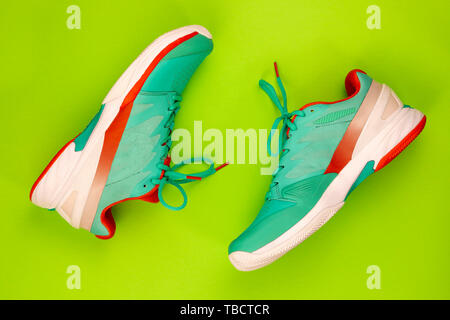 Cyan, rouge, blanc paire de chaussures de tennis en studio shot sur fond vert. Directement à partir de ci-dessus. Banque D'Images