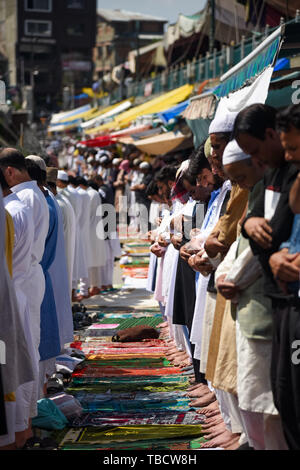 Les musulmans du Cachemire offrir des prières le long d'une route à l'extérieur au cours de Jamia Masjid-ul-Jumat Widah, le dernier vendredi du mois de Ramadan islamique. Le mois le plus saint de l'Islam Le Ramadan est une période de prière intense, l'aube au coucher du jeûne et de fêtes nocturnes. Banque D'Images