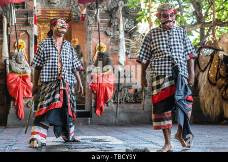 Banjar Gelulung, Bali, Indonésie - 26 Février 2019 : Mas de village. Jouer sur scène. Deux bandits habillés de danse avec chemises à carreaux gris-blanc. Banque D'Images