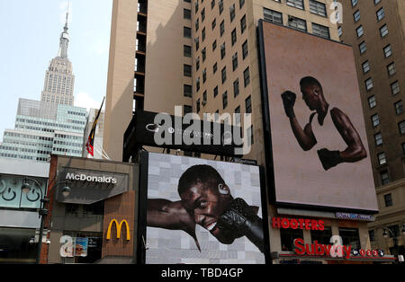 Anthony Josué est présenté sur un panneau d'écouteurs publicité en face de l'Empire State Building, New York. Banque D'Images