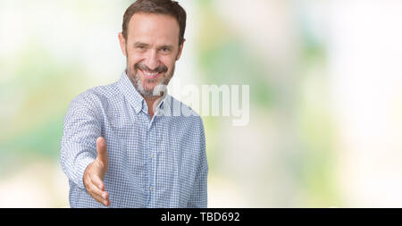 Beau moyen-âge senior homme élégant sur fond isolé smiling friendly offrant comme message d'handshake et accueillant. Réussite de l'entreprise. Banque D'Images