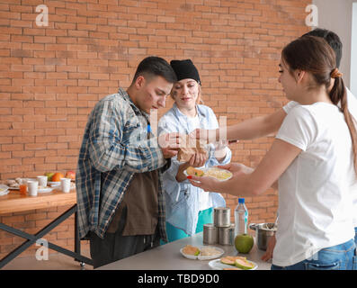 Les jeunes bénévoles en donnant de la nourriture aux pauvres Banque D'Images