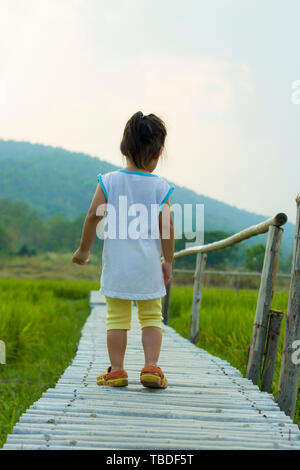 Un petit enfant marche le long de la route de champ de riz, galerie d'images haute résolution. Banque D'Images