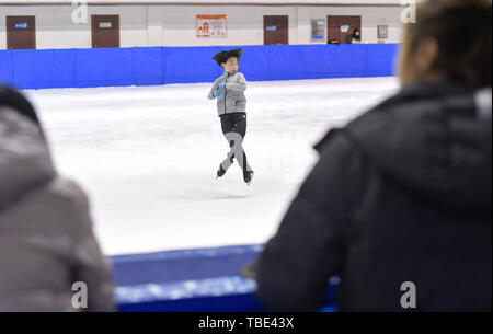 (190601) -- CHANGCHUN, 1 juin 2019 (Xinhua) -- Photo prise le 30 mai 2019 affiche Zhou Yi saute et tourne comme l'entraîneur fait sur la ligne de côté. Zhou Yi, huit ans, est le plus jeune patineur dans une équipe de patinage artistique formé par le Centre d'administration de sports d'hiver Sports de Jilin Bureau. Il a été l'apprentissage du sport pour trois ans et a réclamé le titre de groupe de garçons lors de la 18e Jeux de la jeunesse de la province de Jilin l'année dernière. Zhou assiste à des sessions de formation sur la glace pour plus de 2 heures après la classe. Il prend également d'autres cours pour améliorer son corps, la coordination, la souplesse et l'endurance physique. Je Banque D'Images