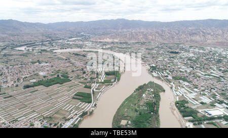 (190601) -- BAIYIN, Juin 1, 2019 (Xinhua) -- photo aérienne prise le 29 mai 2019 présente le paysage de fleuve Jaune le Qiangwan à proximité Village de Baiyin ville du nord-ouest de la Chine, la province du Gansu. Les villageois de Qiangwan Qinqiang Village sont friands de l'opéra, un opéra chinois populaire dans le nord-ouest de la Chine. Au lieu de l'exécution de l'art sur une scène construite à environ près de la rivière Jin'gou en proie à la pollution dans le passé, les amateurs d'opéra Qinqiang sont maintenant en mesure de montrer leur talent à un pavillon le long de la rivière propre grâce à la gouvernance écologique autour de la rivière lancé par le gouvernement local depuis 2018. Dans l'affaire re Banque D'Images