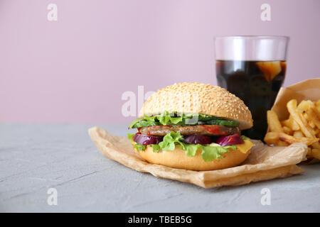 Frais savoureux burger et verre de soda on table Banque D'Images