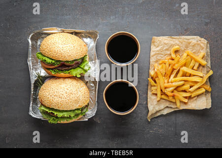 Frais savoureux hamburgers, tasses de soude et french fries on table Banque D'Images