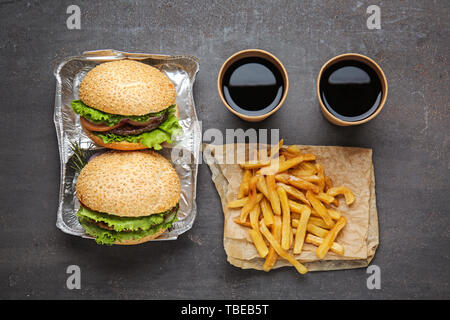 Frais savoureux hamburgers, tasses de soude et french fries on table Banque D'Images