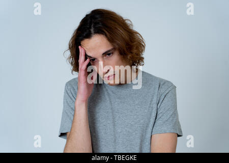 Portrait de jeune homme adolescence triste qui crie dans la douleur émotionnelle à la recherche désespérée et affligé. Millennial homme souffrant de dépression et l'intimidation. En m Banque D'Images