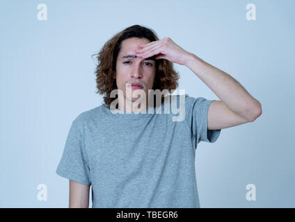 Jeune adolescent à la peur et réfléchie qui souffrent de migraines dans de grandes souffrances. Portrait de milliers d'homme dans la douleur émotionnelle. En soin du expressi Banque D'Images