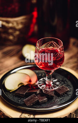 Groseillier rouge maison nalivka et chocolat, avec les tranches de pommes sur le plateau métallique Banque D'Images