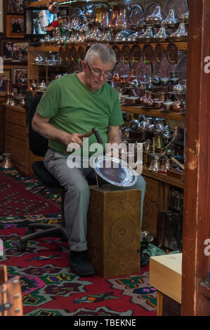 Sarajevo : un chaudronnier au travail à l'intérieur de son atelier dans le chaudronnier sur rue au cœur de Bascarsija, vieux bazar et centre historique de la ville Banque D'Images