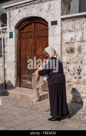 Sarajevo : dame âgé de nappes brodées à la main vente napperons et dans la place Bascarsija, le vieux bazar et le centre historique de la ville Banque D'Images