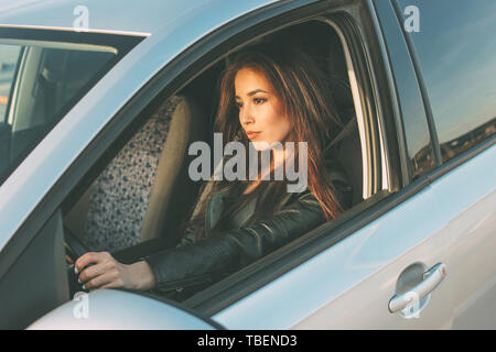 Belle brune cheveux longs young asian woman driving la voiture voyageurs Banque D'Images