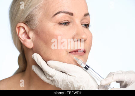 Young woman receiving injection en face sur un fond de couleur Banque D'Images