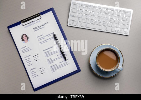Reprise d'emploi avec clavier de l'ordinateur et tasse de café sur fond gris Banque D'Images
