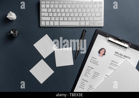 Reprise d'emploi avec clavier de l'ordinateur de bureau et de papeterie sur fond sombre Banque D'Images
