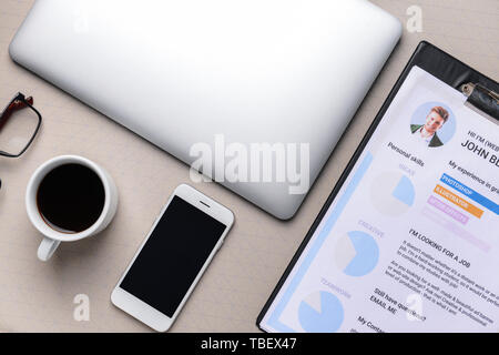 Reprendre d'emploi avec un ordinateur portable, téléphone mobile et tasse de café sur fond gris Banque D'Images