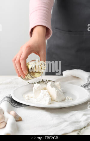 Tasty Woman pouring olive oil sur le fromage feta, gros plan Banque D'Images