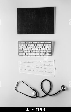 La composition avec stéthoscope, cardiogrammes et clavier de l'ordinateur, sur fond blanc. Concept de consultation médicale en ligne Banque D'Images