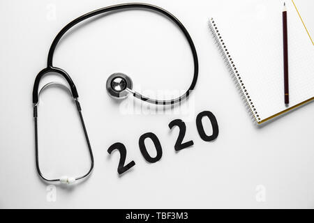 Stéthoscope, ordinateur portable et la figure 2020 sur fond blanc Banque D'Images