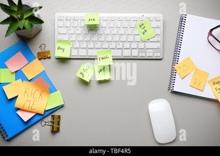 Clavier de l'ordinateur à l'aide de modèles et des notes autocollantes sur fond gris. Poisson d'avril farce Banque D'Images
