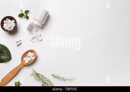 Composition avec les pilules à base de plantes sur fond blanc Banque D'Images