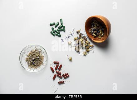 Composition avec les pilules à base de plantes sur fond blanc Banque D'Images