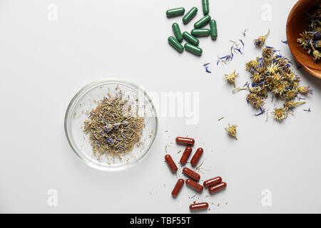 Composition avec les pilules à base de plantes sur fond blanc Banque D'Images