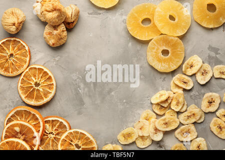 Cadre fait d'un assortiment de fruits secs sur fond gris Banque D'Images