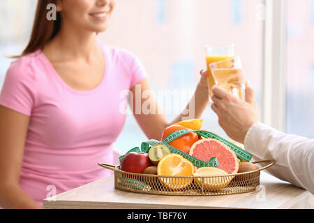 Fruits frais avec ruban à mesurer sur le tableau de la nutritionniste Banque D'Images