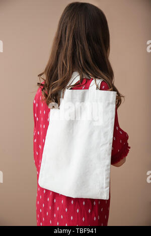 Jeune femme avec eco sac sur fond couleur, vue arrière Banque D'Images