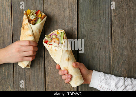 Femmes avec de délicieux döner kebab sur fond de bois Banque D'Images