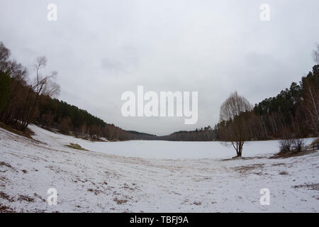 Moody paysage avec lac gelé d'hiver couleur gris. Banque D'Images