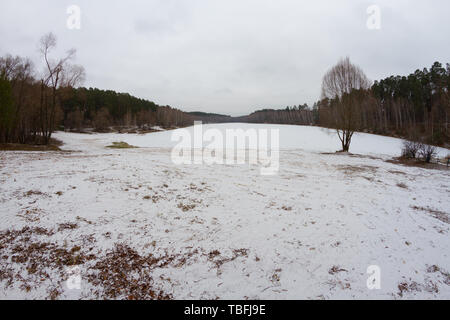 Moody paysage avec lac gelé d'hiver couleur gris. Banque D'Images